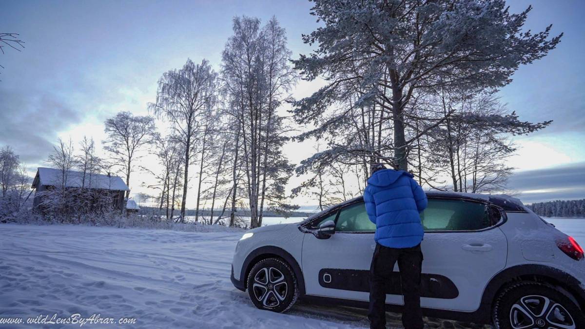 Cleaning the frozen wind shield and windows of car